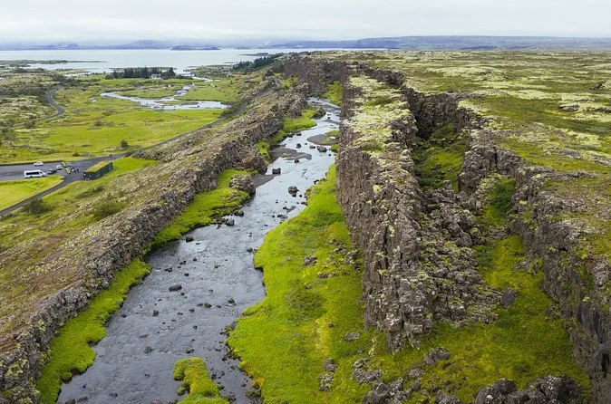 Aerial view of the Þingvellir rift valley in summer, with a river running between mossy lava walls